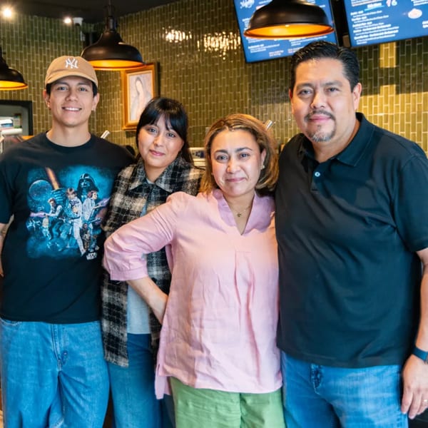 Four smiling Miguelito's Cocina Mexicana staff members, two men and two women, stand together.