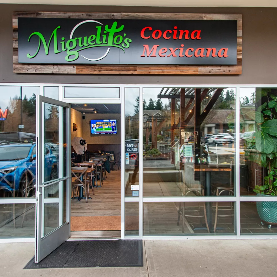 Exterior view of Miguelito's Cocina Mexicana entrance with open door and visible interior dining area.