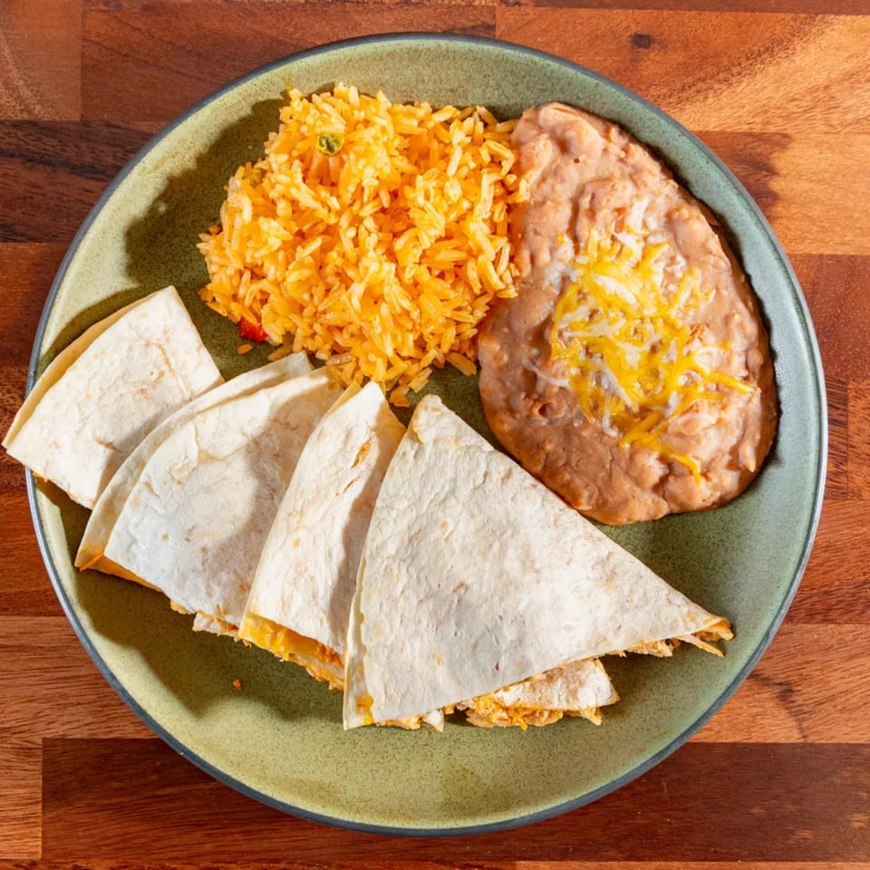 Miguelito's Cocina Mexicana cheese quesadillas with Mexican rice and refried beans on a green plate.