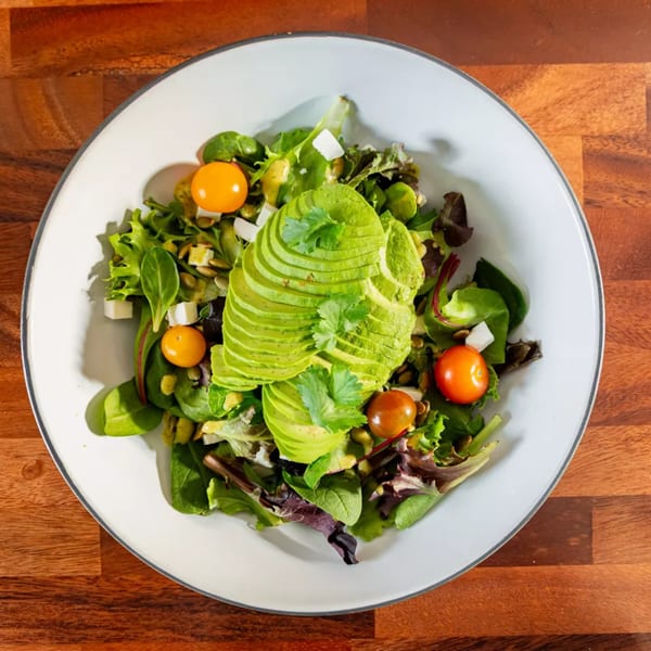 Miguelito's Cocina Mexicana's vibrant salad with sliced avocado, mixed greens, cherry tomatoes, and pumpkin seeds.